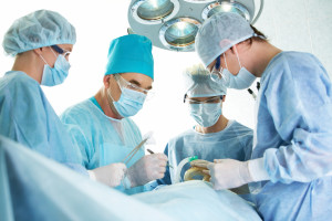 Several surgeons surrounding patient on operation table during their work
