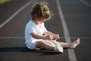 little girl learning to tie shoelaces