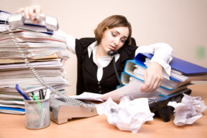 Young businesswoman with tons of documents