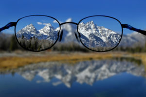 Glasses with clear vision of Teton Mountains in background signifying power of clarity to improve productivity