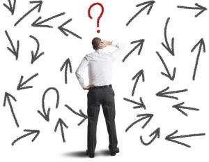 man surrounded by diverging arrows and one question mark